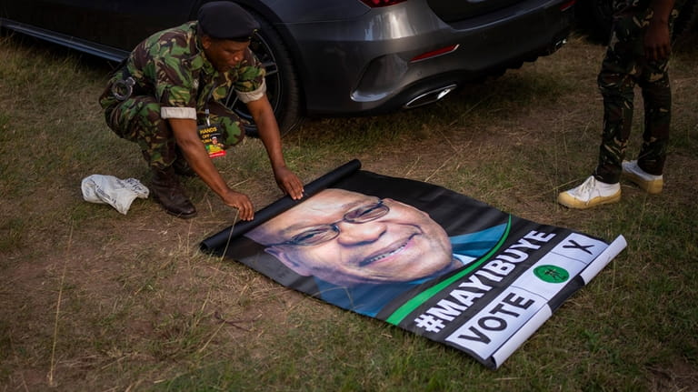 A military officer rolls up a poster of former South...