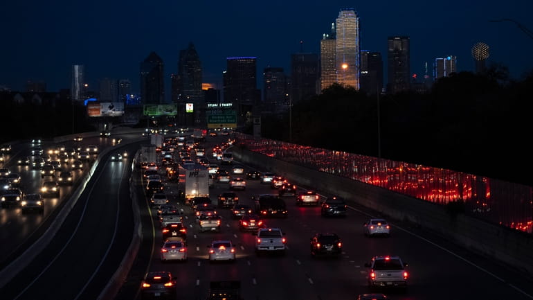 Vehicles travel along Interstate-30 with the Dallas skyline seen in...