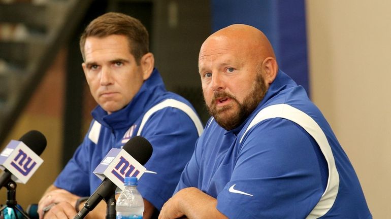 Giants head coach Brian Daboll (right) talks to the media...