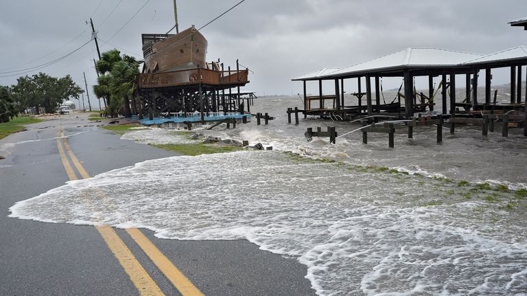 Storm surge breaks over a small sea wall near boat...