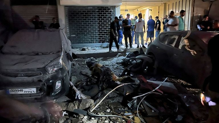 People inspect damaged cars in the southern suburbs of Beirut,...