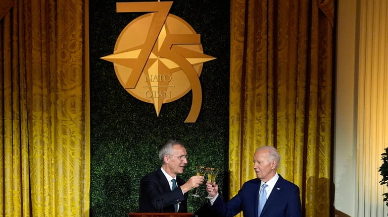 President Joe Biden toasts with NATO Secretary General Jens Stoltenberg...