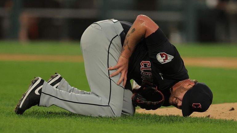 Cleveland Guardians' pitcher Ben Lively lays on the field after...