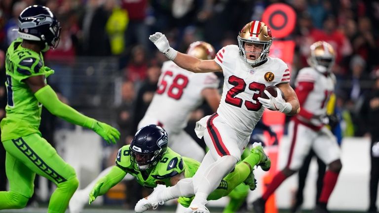 San Francisco 49ers running back Christian McCaffrey (23) pulls away...