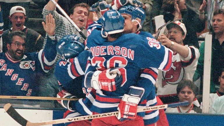 The Rangers' Stephane Matteau is embraced by teammates Glenn Anderson,...