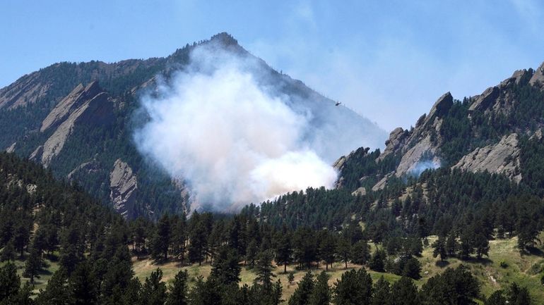 Smoke rises from a fire burning south of NCAR in...