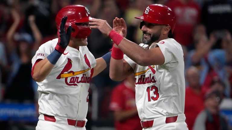 St. Louis Cardinals' Matt Carpenter (13) is congratulated by teammate...