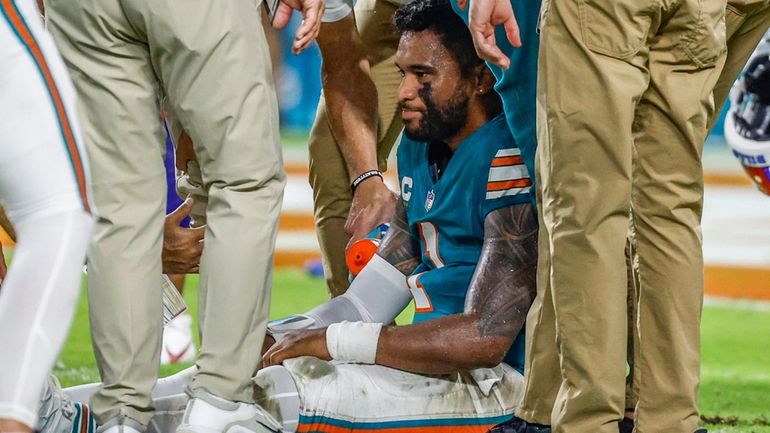 Miami Dolphins quarterback Tua Tagovailoa (1) sits on the field...