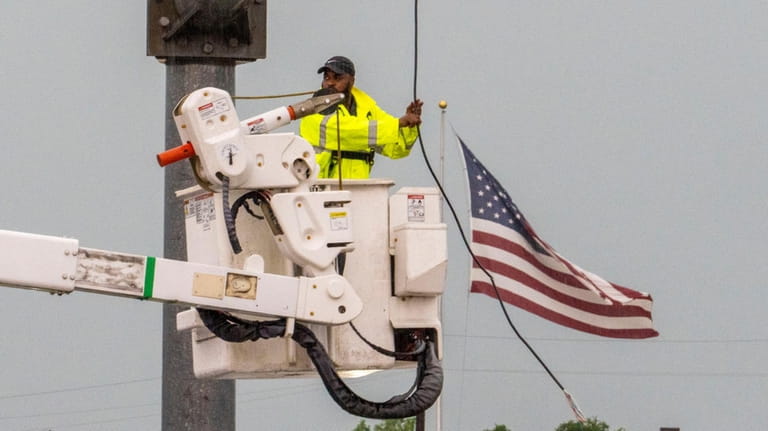 A Pearland city worker attempts to repair a broken power...