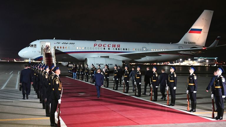 Russian President Vladimir Putin, center back to a camera, arrives...