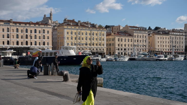 A woman walks along the Vieux Port in Marseille, southern...