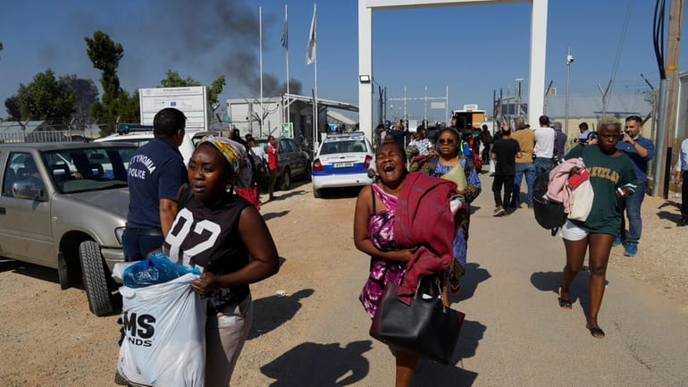 Female migrants exit the Pournara migrant reception center following fighting...