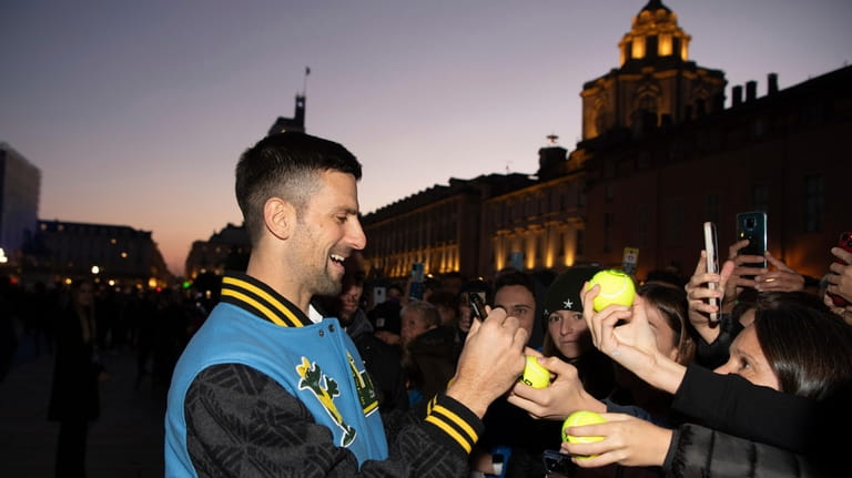 Serbia's Novak Djokovic signs autographs during the Blue Carpet &...