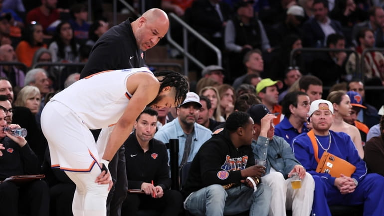 Knicks assistant coach Rick Brunson talks with his son Jalen...