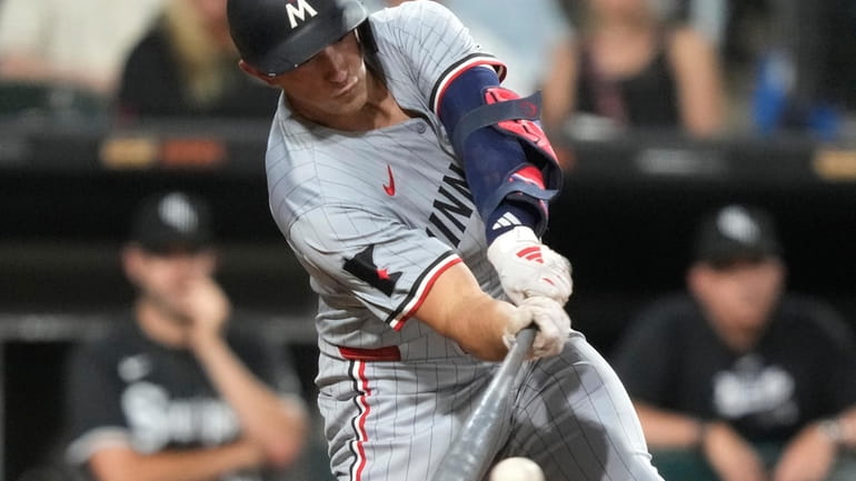 Minnesota Twins' Brooks Lee hits an RBI single in the...