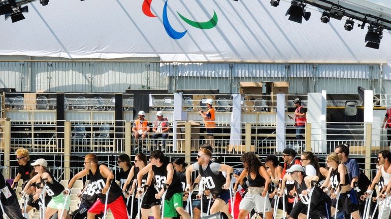 A group of dancers use crutches during the rehearsal of...