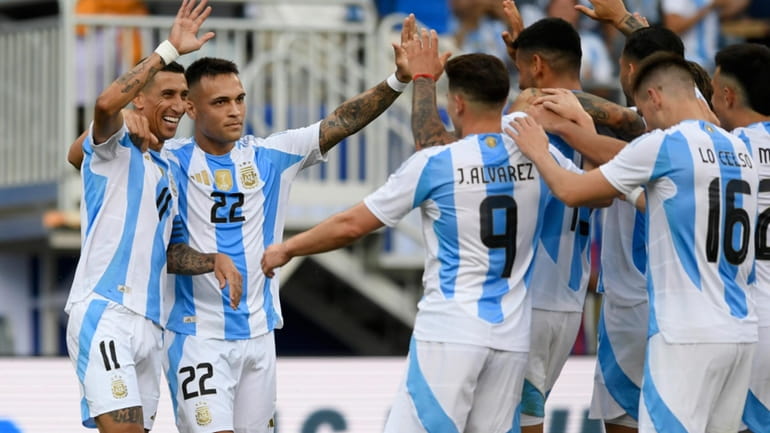 Argentina's Angel Correa (11) celebrates with teammates after scoring during...