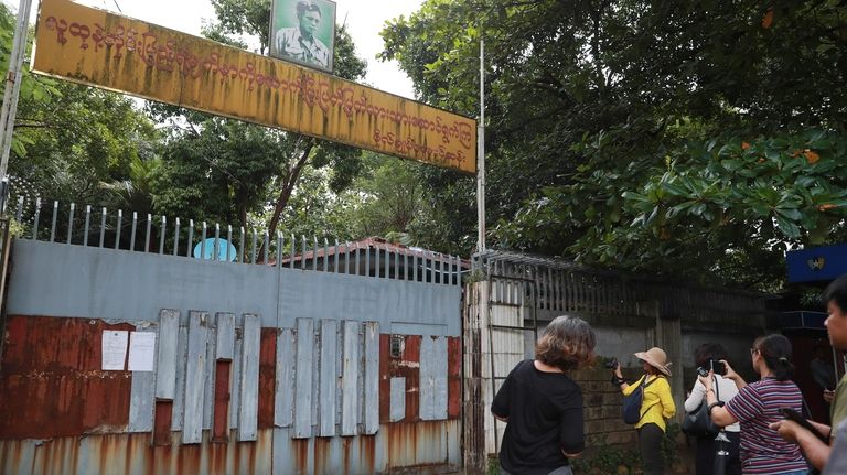 Journalists gather outside the residence of ousted leader Aung San...