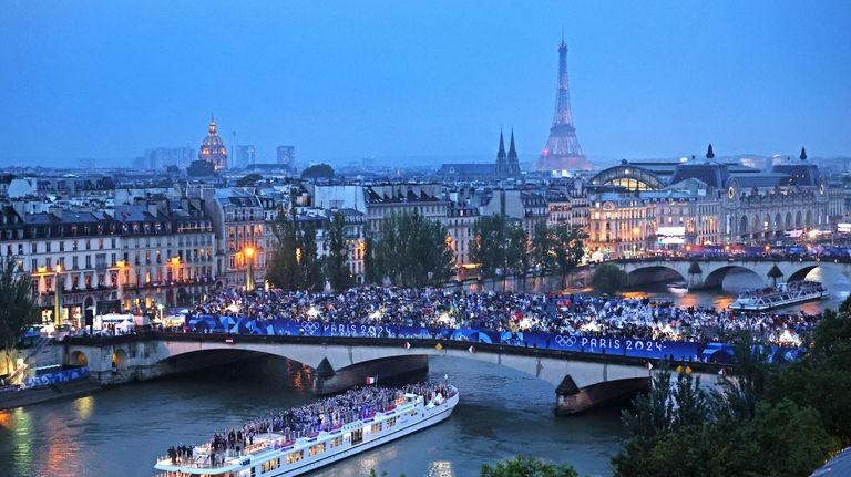 Spectators look on as athletes from Team France cruise on...