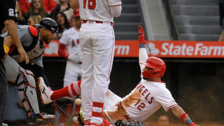 Los Angeles Angels' Kevin Pillar, right, scores on a wild...