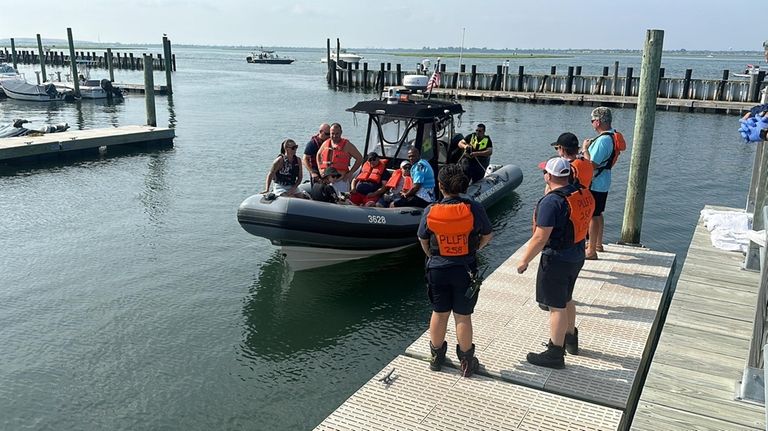 Passengers from the distressed boat come ashore at the West...