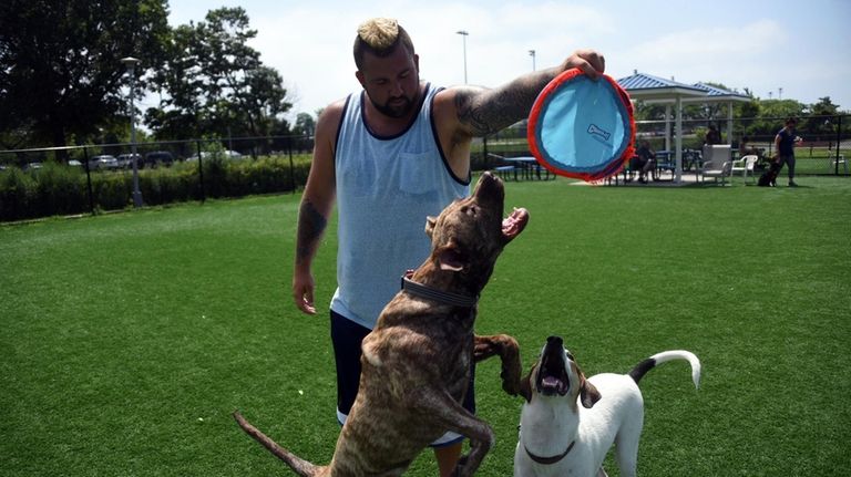 George Fiore of Levittown plays with his dog and other...