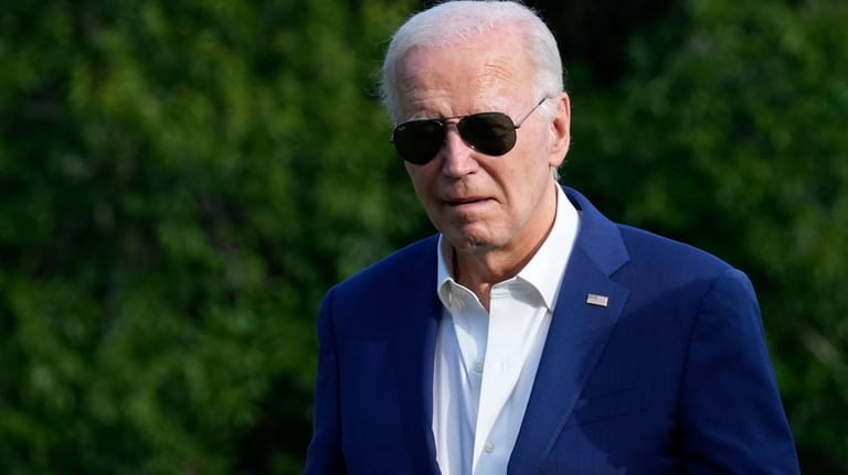 President Joe Biden walks across the South Lawn of the...