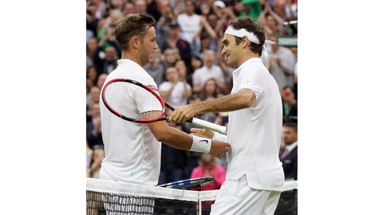 Roger Federer of Switzerland shakes hands with Marcus Willis of...