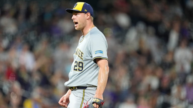 Milwaukee Brewers relief pitcher Trevor Megill reacts after striking out...