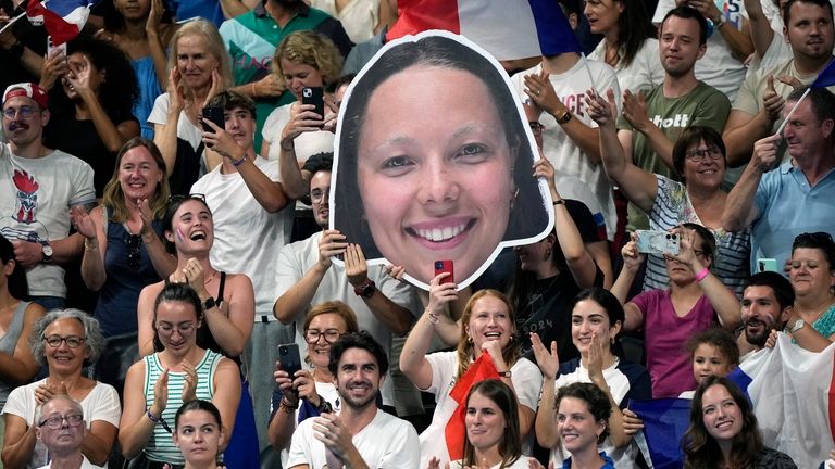 Spectators hold a placard with the face of France's Emeline...