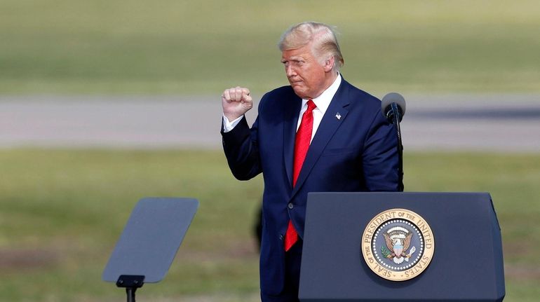 President Donald Trump pumps his fist after speaking at a...