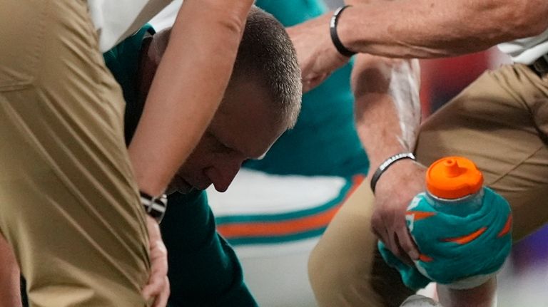 Miami Dolphins quarterback Tua Tagovailoa (1) is assisted on the...