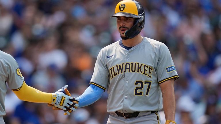 Milwaukee Brewers' Willy Adames celebrates after scoring on a single...