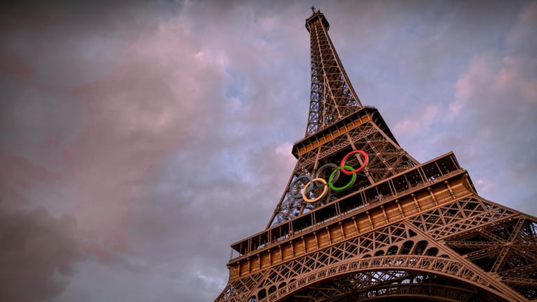 The Olympic rings are seen on the Eiffel Tower ahead...
