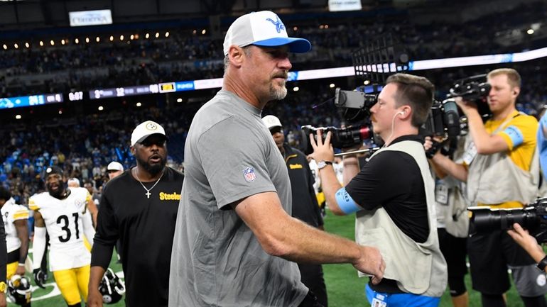 Detroit Lions head coach Dan Campbell walks off the field...