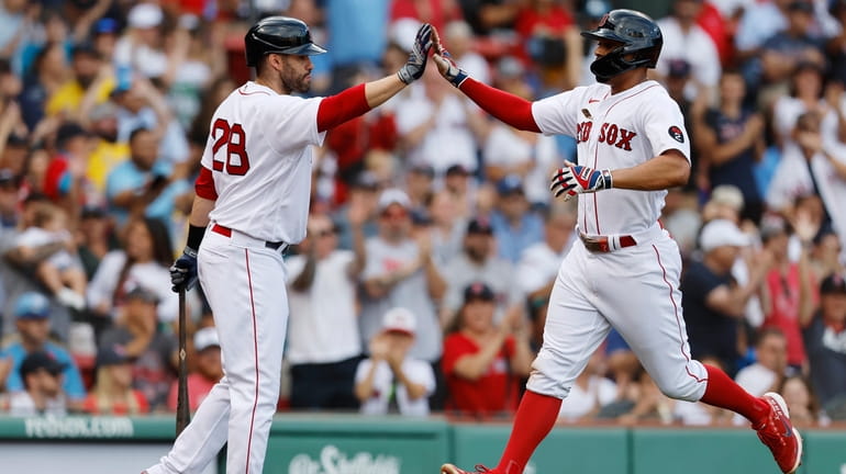 Boston Red Sox's Xander Bogaerts celebrates with J.D. Martinez (28)...