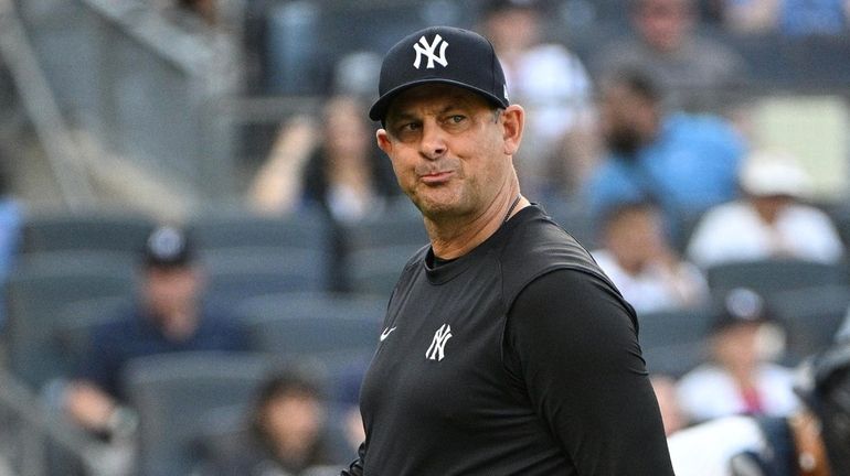 Yankees manager Aaron Boone walks to the dugout after a...