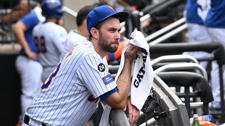 Mets starting pitcher David Peterson looks on from the dugout...