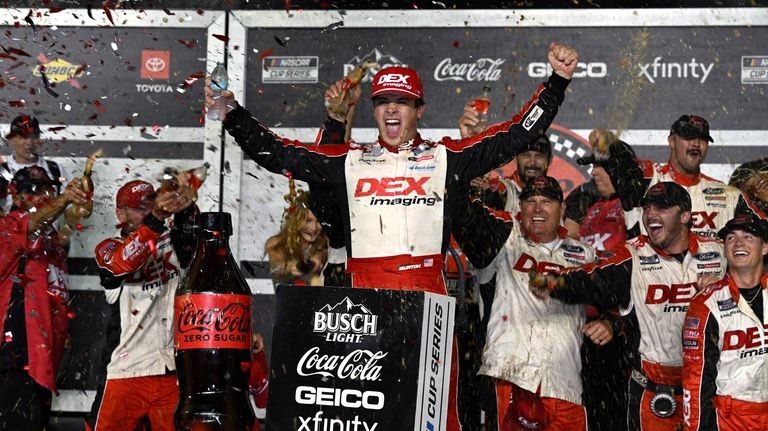 Harrison Burton celebrates in Victory Lane after winning a NASCAR...