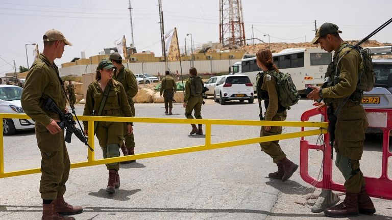 Israeli soldiers secure a gate leading to a military base...