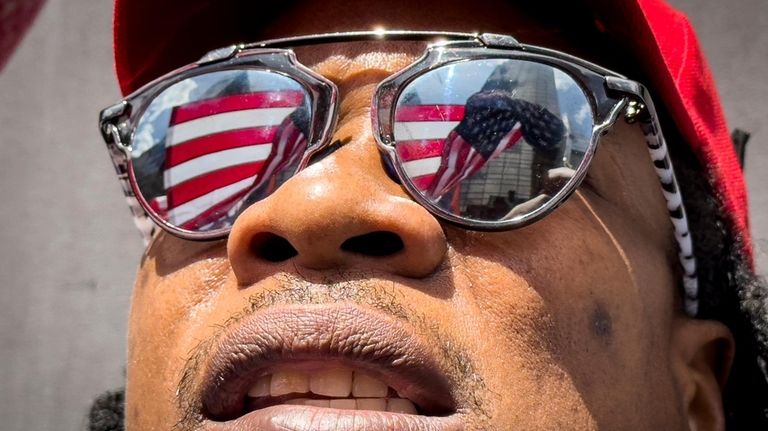 A supporter of former President Donald Trump waves an inverted...