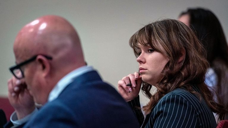 Hannah Gutierrez-Reed, center, sits with her attorney Jason Bowles, left,...