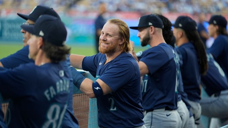 Seattle Mariners' Justin Turner smiles in the dugout before a...