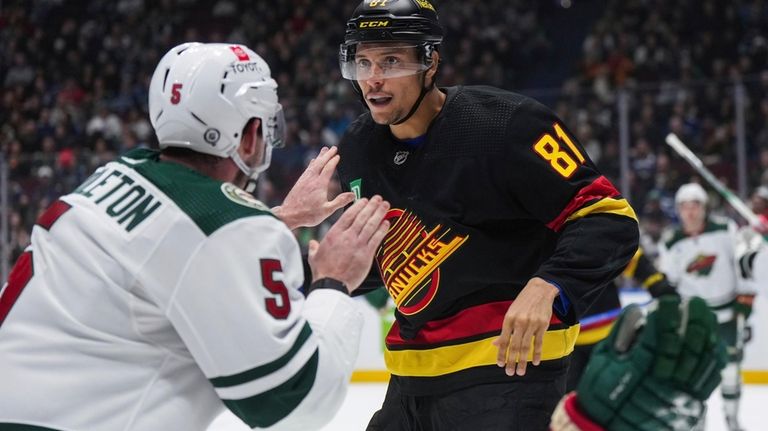 Vancouver Canucks' Dakota Joshua, right, and Minnesota Wild's Jacob Middleton...