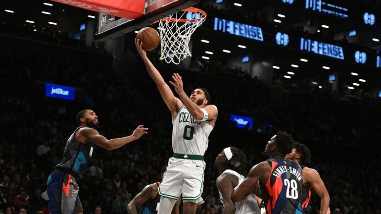 Boston Celtics forward Jayson Tatum scores a layup against the...