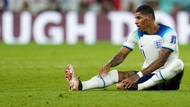 England's Marcus Rashford sits on the field during the World...