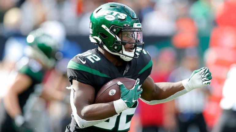 Michael Carter of the Jets runs the ball against the Bengals...