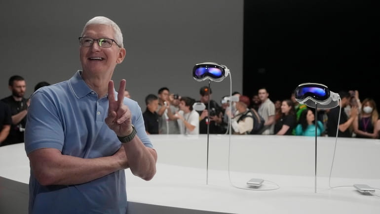 Apple CEO Tim Cook poses for photos in front of...