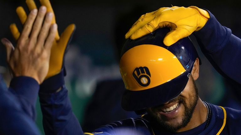 Milwaukee Brewers' Blake Perkins is congratulated by teammates in the...