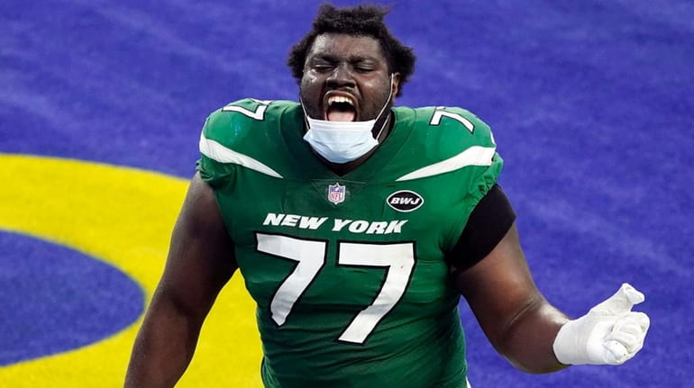 Jets offensive tackle Mekhi Becton celebrates as he runs off...
